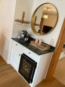 a bathroom with a counter with a fireplace and a mirror at Casa Natur Pur, 85m2 mit Garten Sauna in Fischbachau +55 photos