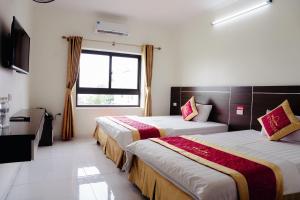 a hotel room with two beds and a window at VIET HOUSE HẠ LONG HOTEL in Ha Long