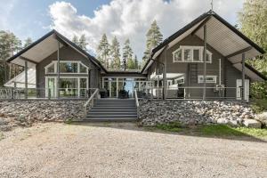 ein großes Haus mit einer Steinmauer in der Unterkunft Lehmonkärki Resort in Asikkala