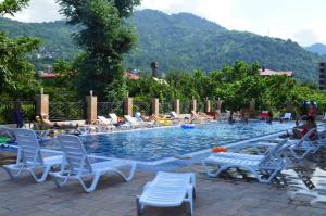 a pool with lounge chairs and people laying in the water at Euro Palace Gonio in Gonio