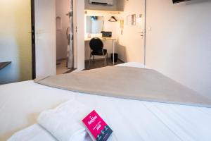 a hospital room with a bed with a red sign on it at Fasthôtel - Un hôtel FH Confort in Limoges