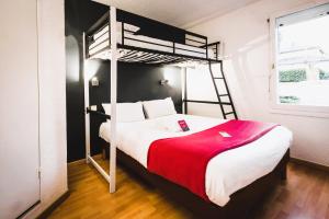 um quarto com um beliche e um cobertor vermelho em Fasthôtel - Un hôtel FH Confort em Limoges