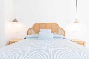 een bed met een blauw en wit gestreept bed bij Roses Casc Antic SL Sabater 5 in Roses