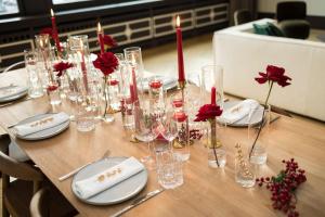 a table with glasses and red candles and red flowers at City Luxury: 3BR, Prime Location in Brussels