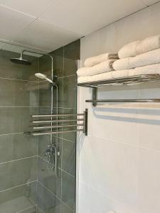 a bathroom with a shower with towels on a shelf at Villa Alexia - APARTMENT CORAL - Puerto Pollensa in Port de Pollensa