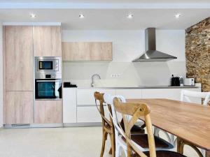 a kitchen with a wooden table and a stove top oven at Roses Casc Antic Sl Sabater 4 in Roses +6 photos