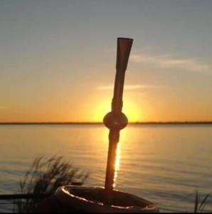 a pole in the water with the sunset in the background at SOMBRAS DEL PARANA Apart Misiones in Eldorado