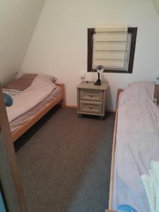Un dormitorio con dos camas y una lámpara en una mesita de noche. en Vikendica Stars, en Jahorina