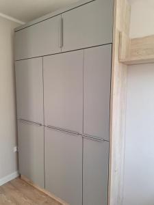 a closet with white cabinets in a room at Apartament Kamienny Potok Sopot in Sopot