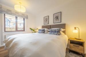 Un dormitorio con una gran cama blanca y una ventana en The Pullman en Sheringham