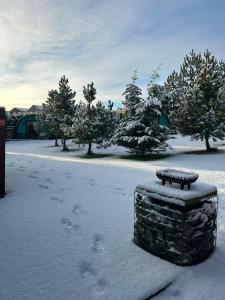 a snow covered park with a bench in the snow at Original Glamping Pod with Hot Tub in Frodsham