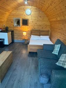 a bedroom with a bed and a couch in a room at Original Glamping Pod with Hot Tub in Frodsham