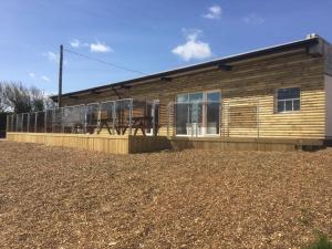 una casa con una terraza con sillas. en Original Glamping Pod with Hot Tub en Frodsham