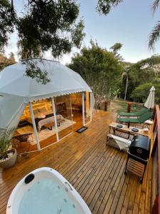 a hot tub on a wooden deck with a gazebo at GOAT LODGE Domo Pitanga in Ibiúna