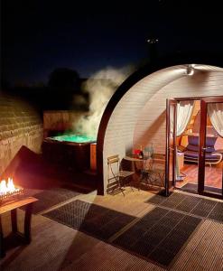 a tunnel with a bed and a table in a room at Original Glamping Pod with Hot Tub in Frodsham