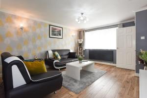 a living room with a couch and a table at Spacious 4-Bed Family House in Portsmouth