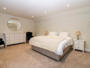a bedroom with a large bed and a mirror at 8 Barney Mains Cottage in Haddington