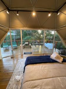 a bedroom in a tent with a bed in it at GOAT LODGE Domo Pitanga in Ibiúna