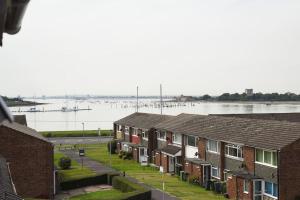 a row of houses next to a body of water at Spacious 4-Bed Family House in Portsmouth