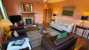 East Wing Apartment في ويموندهام: غرفة معيشة مع أريكة ومدفأة