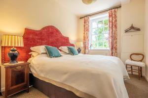 Schlafzimmer mit einem großen Bett mit einem roten Kopfteil in der Unterkunft East Wing Apartment in Wymondham