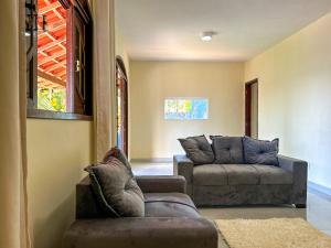 sala de estar con 2 sofás y sofá en Casa de campo c vista para a Lagoa de Saquarema RJ, en Saquarema