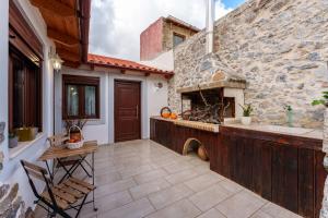 a patio with a stone fireplace in a house at Petrino House Lasithi in Agios Georgios
