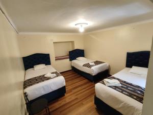 une chambre d'hôtel avec deux lits et deux chaises dans l'établissement Qosqo Apartments 3, à Cusco