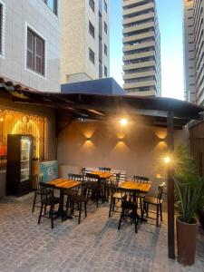 een patio met tafels, stoelen en gebouwen bij Algas Praia Hotel in Fortaleza