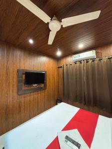 a bedroom with a bed with a ceiling fan and a tv at Hotel Borivali Executive - Near Borivali Railway Station in Mumbai