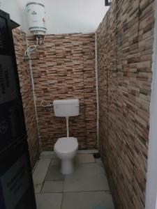 ein Bad mit einem WC in einer Ziegelwand in der Unterkunft Nagpur Tuljai Villa Homestay in Khāpri