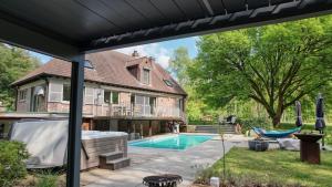 un patio trasero con piscina y una casa en Arthur's palace, en Heusden - Zolder