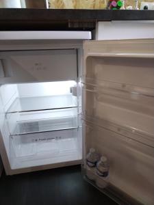 an empty refrigerator with its door open in a kitchen at Studio, La terrasse d'Isa in Dole