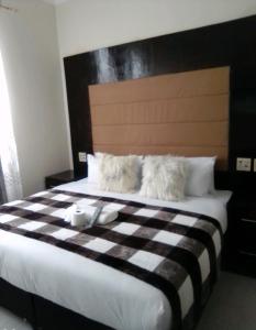 uma cama com um cobertor xadrez preto e branco em DBright Lodge em Pretoria