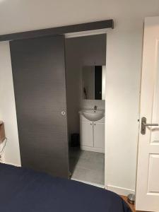 a bedroom with a door to a bathroom with a sink at F2 à 500 m centre ville et gare - 1er étage in Soissons