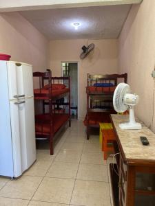Il comprend une cuisine équipée d'un réfrigérateur et d'une table avec un ventilateur. dans l'établissement Casa 2, à Praia Grande