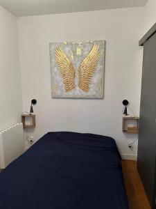 a bedroom with a bed with wings on the wall at F2 à 500 m centre ville et gare - 1er étage in Soissons