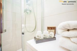 a bathroom with white towels and a shower at Baltic Apartments - Apartamenty Aquamarina in Świnoujście +75 photos