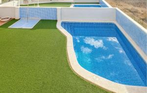 an overhead view of a swimming pool with green grass at Nice Apartment In Moncofa Playa With Outdoor Swimming Pool in Moncófar