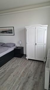 Ilmmünster的住宿－Black & White，一间白色卧室,配有床和橱柜