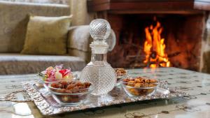 a tray with three bowls of food on a table with a fireplace at Petrino House Lasithi in Agios Georgios