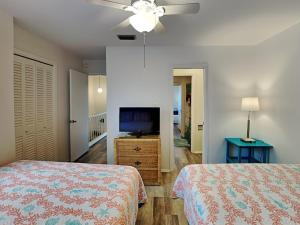 a bedroom with two beds and a flat screen tv at La Vida Buena in Rockport