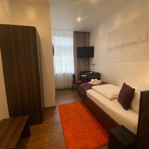 ein Schlafzimmer mit einem Bett und einem Schreibtisch in einem Zimmer in der Unterkunft sevenDays Hotel Karlsruhe in Karlsruhe