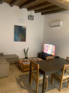 uma sala de estar com uma mesa e uma televisão em Almirante Brown 235 , Dpto 5 em San Martín