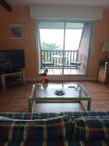 a living room with a couch and a glass table at le cottage vue mer in Bénerville-sur-Mer +18 photos