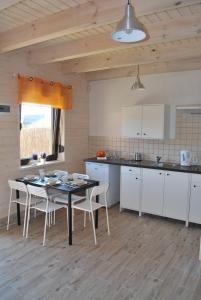 a kitchen with white cabinets and a table and chairs at 11 Maków in Mielenko