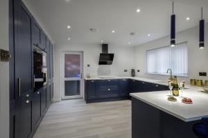 a kitchen with blue cabinets and a white counter top at Belverdale by STAMP SA in Blackpool
