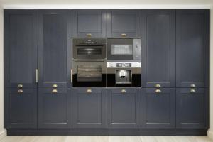 a kitchen with navy blue cabinets and appliances at Belverdale by STAMP SA in Blackpool