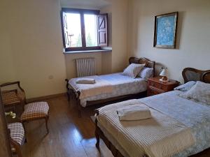 a bedroom with two beds and a window at Palacio Marqués Vega de Anzo - Villa de campo sXVII in Siero