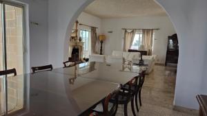 a dining room and living room with a table and chairs at Stunning Villa with Pool, Table tennis, Table soccer and a Pool table in Naxxar